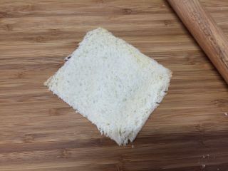 4、#吐司新吃法之四#香肠吐司卷,用擀面杖擀压吐司片，使其紧实扁平