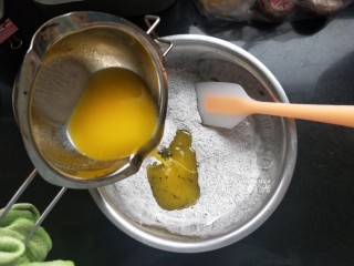 3、黑芝麻馅料,黄油趁热倒入粉盆里