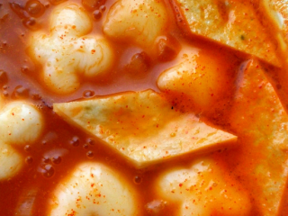 5、辣炒年糕,中火煮年糕，边煮边搅动，防止粘底，收汤至一半时，加入鱼饼