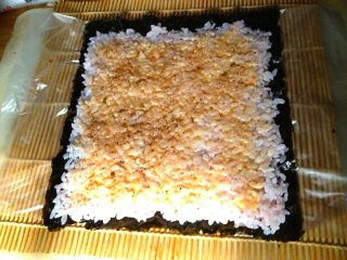 2、韩式菜包饭,如图，把搅拌好的饭铺在紫菜上，并撒上千岛酱和椒盐