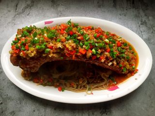 16、过桥排骨,将锅里剩的浇头全部淋在排骨上，撒上葱花即可食用。