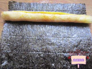 4、花朵????寿司????,取一张紫菜，放上蛋卷，卷一圈之后，剪去多余部分，边缘处沾一点凉开水粘牢