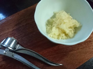 4、蒜蓉粉丝蒸金针菇,用压蒜器压成蓉。