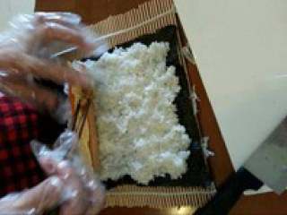 4、日式紫菜卷,把紫菜放在竹板上，在把米饭摆好，把准备好的青瓜，火腿，胡萝卜和蛋皮放进去。