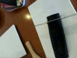 6、日式紫菜卷,裹好后在把竹板打开，把紫菜卷放进盘子里用刀切成段。