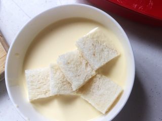 8、焗烤英式布丁,将吐司块放入蛋白液中浸泡个五、六秒