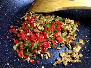 4、肉末粉丝煲,将青椒红椒洗净剁碎，肉变色后，放入辣椒末
