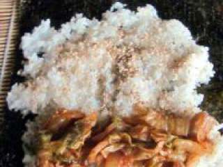 6、紫菜泡菜包饭,再均匀的撒上熟芝麻。放上辣白菜。