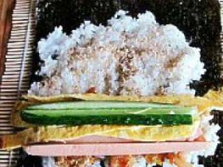 7、紫菜泡菜包饭,依次放入黄瓜，鸡蛋皮，火腿肠。