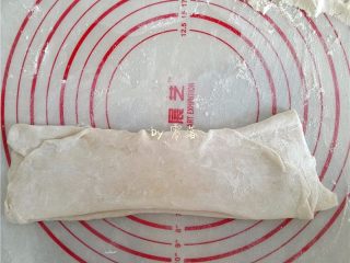 3、酸辣热干面,揉面垫上撒适量面粉，将面团擀成大面块，像折扇子一般折起来；