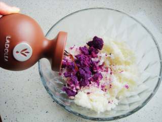 2、紫薯花瓣寿司,大米放入盆中，倒入紫薯泥，加入拉多蕾娅果醋。