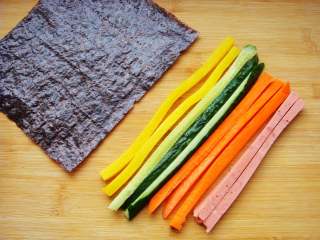 4、紫薯花瓣寿司,香肠、胡萝卜、黄瓜、萝卜条分别切细长条，海苔备用。