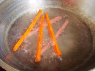 5、紫薯花瓣寿司,胡萝卜、香肠条入开水锅里烫软。