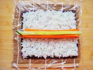 11、紫薯花瓣寿司,再铺上一层白米饭，白米饭提前加入适量果醋搅拌下。中间放上食材。