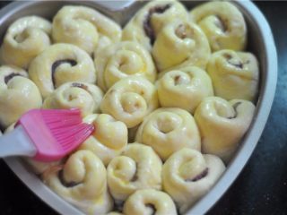 11、紫薯红豆卷,将面包胚放入温暖湿润的地方二发至两倍大，刷上一层鸡蛋液