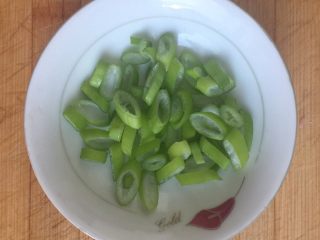 2、电饭煲火腿煲仔饭,植物油倒入电饭煲内胆，浅没过底，按煮饭键热油，油过之后放入葱花，翻炒至散出葱香，倒入鸡蛋。这里的鸡蛋只是辅料，因电饭煲温度不高，翻炒几下后还是液态，趁这时放入火腿丁进行翻炒，直至蛋液将火腿丁基本均匀包裹。