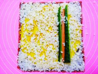 4、鸡蛋的华丽变身②#挑战鸡蛋的100种做法#,再把米饭在上面铺满,压紧,再放上青瓜,火腿, (米饭蒸好时,可以加上油盐或醋搅拌一下更有味哦)