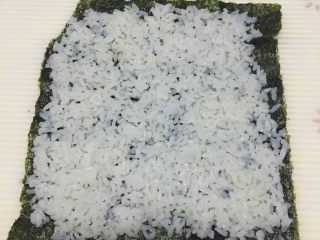 2、简易寿司,在紫菜上铺上米饭。要薄点。放平。