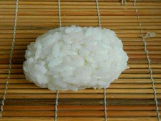 4、日式军舰寿司,手上沾上蒜寿司醋，取一团米饭捏成椭圆形饭团。