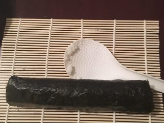 1、简易????寿司????,  将靠近身体这侧往前卷紧，用刀切成小卷！