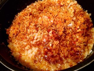 25、鲜虾瑶柱酱(详细版),接着将浸泡了酱料的瑶柱和虾全部倒进洋葱锅里,搅拌均匀。