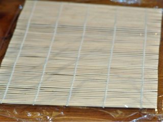 1、黑米肉松卷,寿司帘铺上保鲜膜