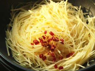 10、红油土豆丝,下入干辣椒末。