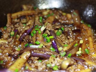 14、下饭菜????肉末茄子,加入小米椒后继续翻炒,最后撒上葱花即可