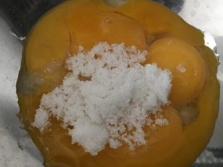 4、味淋香葱烟囱戚风蛋糕,蛋黄加入细砂糖搅拌至糖融化，如果温度比较低，可以在料理盆下方放一盆温水；