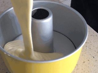 15、味淋香葱烟囱戚风蛋糕,将面糊倒入模具中。倒入的时候尽量保持30cm左右的高度，这样能够排出面糊中的大气泡。倒好后，拇指扣住烟囱，其他手指抓住模具边缘，上下震动几次，排出剩余的气泡。