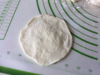 6、鲜肉包子,拿一个剂子用擀面杖擀成边缘薄中间稍厚一点的圆面片。