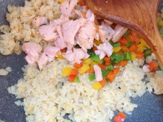 12、彩椒三文鱼蛋炒饭,倒入彩椒和三文鱼，翻炒均匀