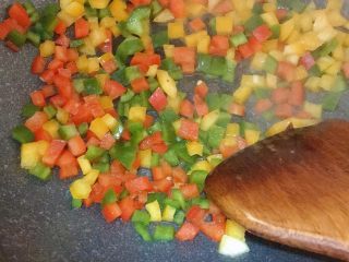 9、彩椒三文鱼蛋炒饭,还是锅内煎三文鱼的油，倒入彩椒翻炒出香味，加适量盐，盛出备用