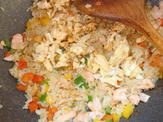 13、彩椒三文鱼蛋炒饭,倒入鸡蛋，加适量生抽调味增色