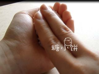 4、章鱼片握寿司,用另一只手的食指和中指按压表面，同时捏紧饭团。完成饭团坯。