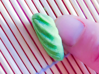 8、猫耳朵面,放在寿司帘子上，用大拇指推压成螺纹型的猫耳朵。