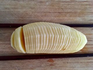 2、风琴土豆,烤箱上下火220度预热。土豆切薄片,下方不切断。可用两根筷子辅助