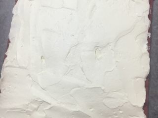 38、红丝绒棉花蛋糕卷,把奶油涂抹在蛋糕胚表面，靠近身体这一侧的奶油多放一些，卷起来才好看，厚厚的，临近卷起接拢的那一端不涂也可以，免得奶油溢出来