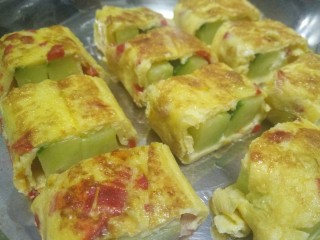 3、韩式蛋卷,用平底锅小火烧热放入一点黄油倒入蛋液（一次不要放太多）不要翻动，看到半凝固时关火放上青瓜条或者蟹条卷起来开火两面煎黄即可，再切成一小结。类似做寿司一样。