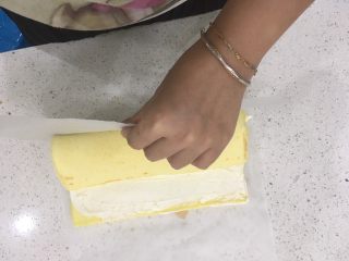 18、经典瑞士卷（原味）,卷好后，慢慢的拉起牛油纸，剩余的蛋糕体就会慢慢收进去了，就是让瑞士卷自己转一圈。