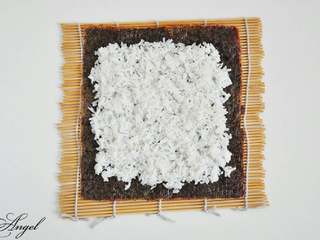 2、踏雪寻莓寿司＃有个故事＃,寿司卷帘平铺与台子上，放上一张海苔，凉透的米饭均匀的铺在海苔上。