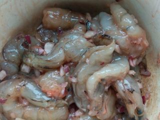 1、小熊米汉堡,鲜虾洗净，去壳，去沙线，加入料酒、胡椒粉、盐、生抽和洋葱碎，腌制一会儿。腌制的同时，将生菜叶洗净备用。