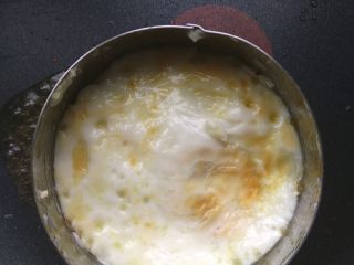 8、小熊米汉堡,七八成熟后，用锅铲小心翻面，牙签沿模具内沿划一圈，让鸡蛋压着虾落到底部，把虾煎熟