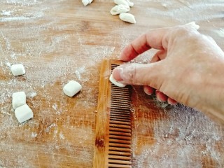 6、烩麻食,借用工具，(寿司帘)，我用专做面三的梳子，按下面丁，向下一搓，麻食搓好！