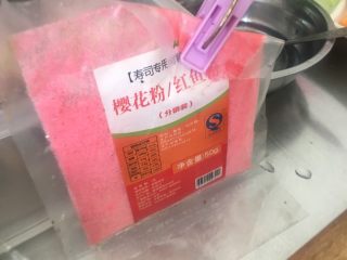 4、翻转樱花寿司,在米饭上撒均匀樱花粉