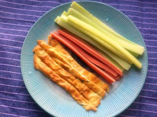 2、超简单寿司做法,切成条状，黄瓜和火腿肠取中间部位切成条状