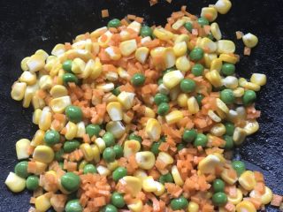8、蔬菜炒饭,等黄油融化后倒入玉米、青豆和红萝卜进行翻炒出香味备用。