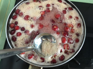 8、自制樱桃果酱,如果表面有浮沫,用勺子撇去浮沫。