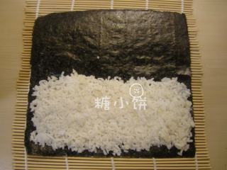 2、玉米笋细卷,在靠下端的一半铺上米饭。因为是细卷，米饭不要铺太多，一半就够如果用半张紫菜的话还可以再少铺一点，堪堪够包裹住夹馅的食材就行。