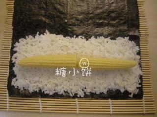 3、玉米笋细卷,米饭的中间摆上煮熟的玉米笋。